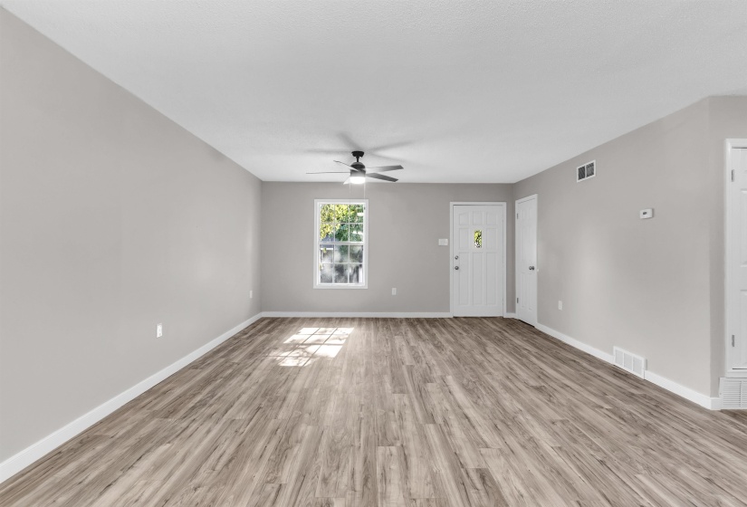 Unfurnished living room featuring light wood finished floors and a ceiling fan