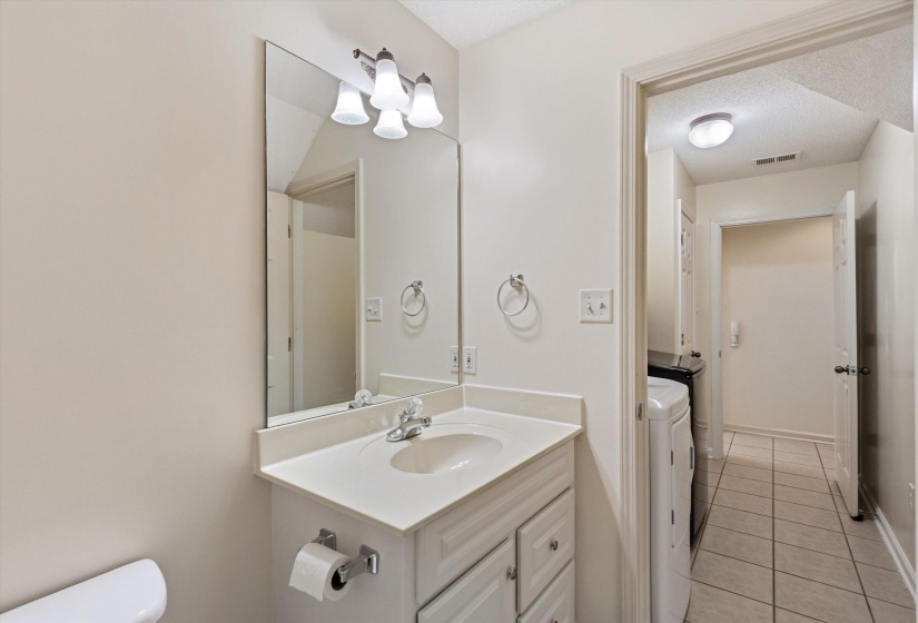 Bathroom vanity featuring a single basin sink, chrome faucet, and cabinet storage