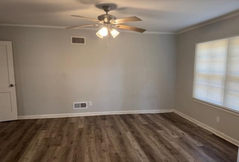 Unfurnished room with ceiling fan, ornamental molding, and dark wood-style floors