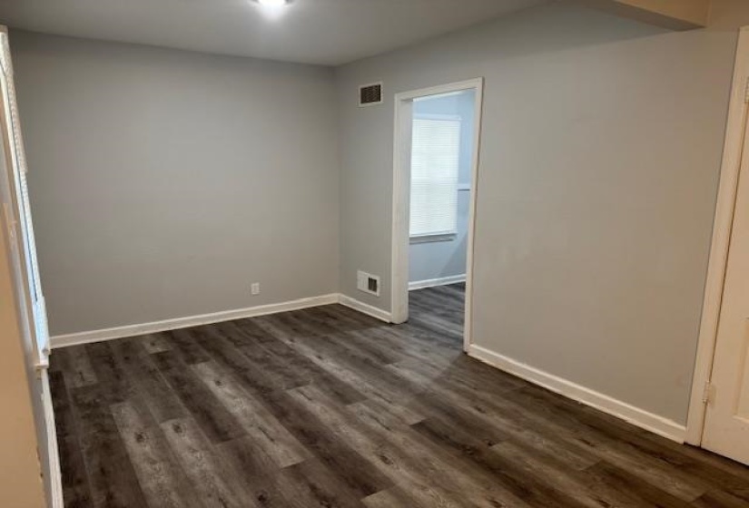 Unfurnished room featuring dark wood-style flooring and baseboards