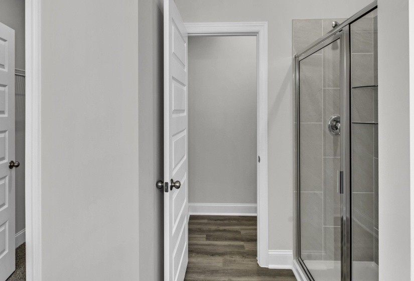 Bathroom with a shower stall and dark wood-style flooring