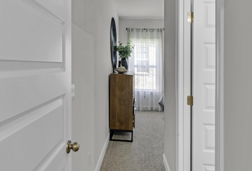 Hall featuring baseboards and light colored carpet