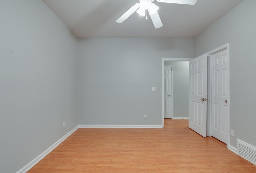 Room with wood-finish flooring, light gray walls, and white trim
