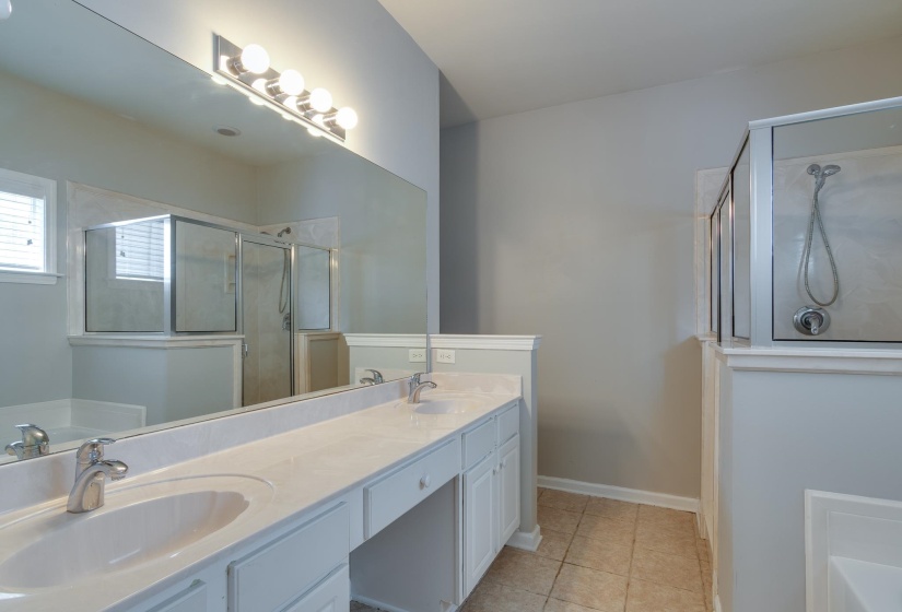 Dual vanity with white cabinetry, light-toned countertops, and chrome fixtures