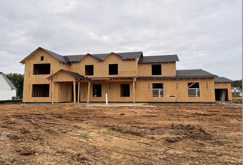 New construction framing with multiple gables and a covered entry