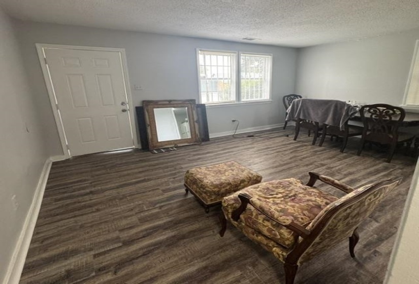 Living space featuring wood-finish flooring, light gray wall paint, and white baseboards