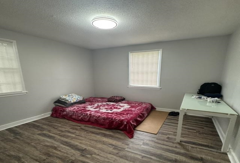 Room featuring wood-finish flooring, light gray wall paint, and white trim
