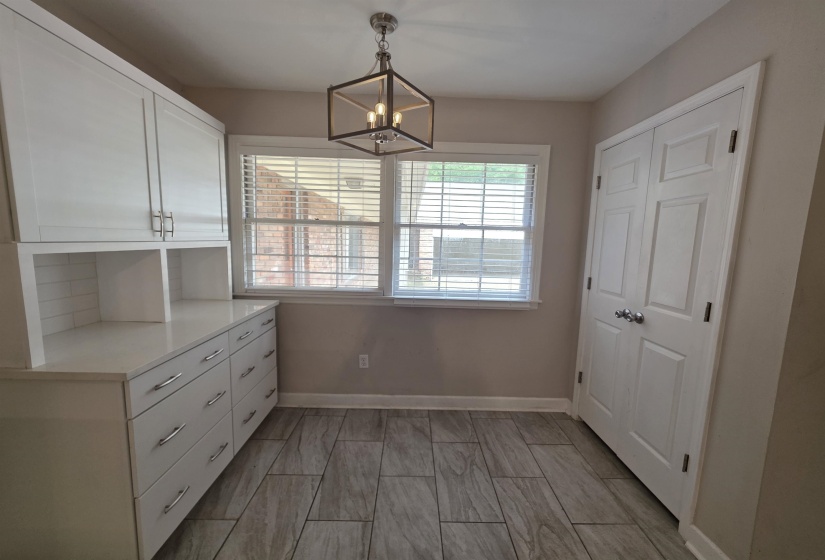 Built-in white cabinetry with a light-toned countertop and subway tile backsplash