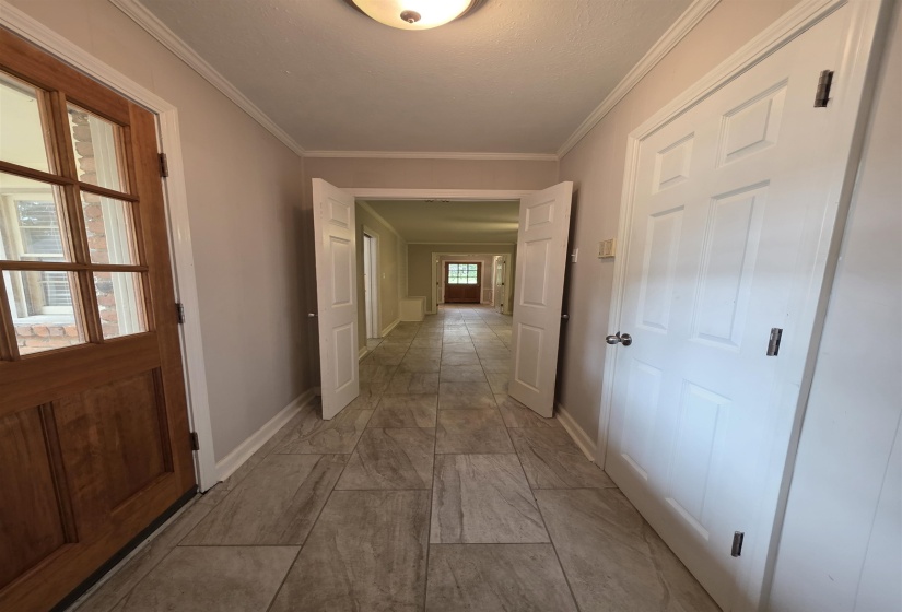 Hallway featuring wood-look tile flooring, crown molding, and recessed lighting