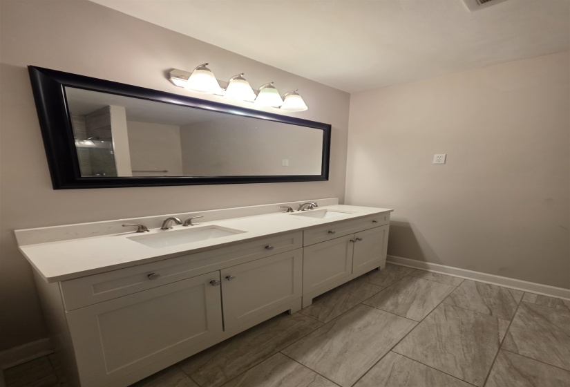 Dual vanity with white shaker-style cabinetry, white countertops, and integrated rectangular sinks