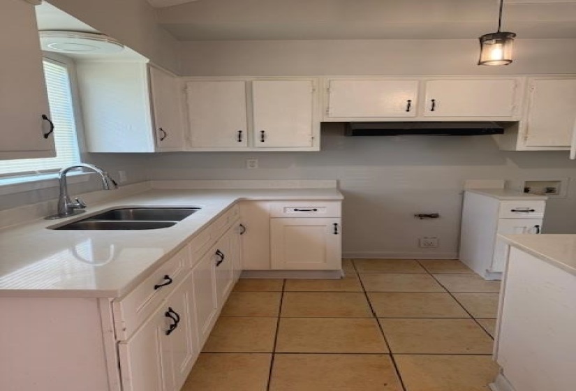 Kitchen featuring light countertops and white cabinetry