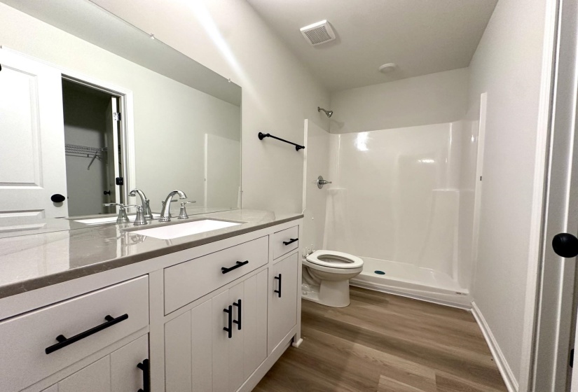 Bathroom featuring a white vanity with black hardware, a light-toned countertop, and a rectangular undermount sink with chrome fixtures