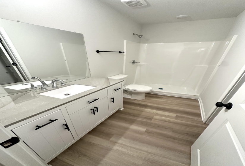 Bathroom featuring a white vanity with matte black hardware, an integrated sink, and a light-toned countertop