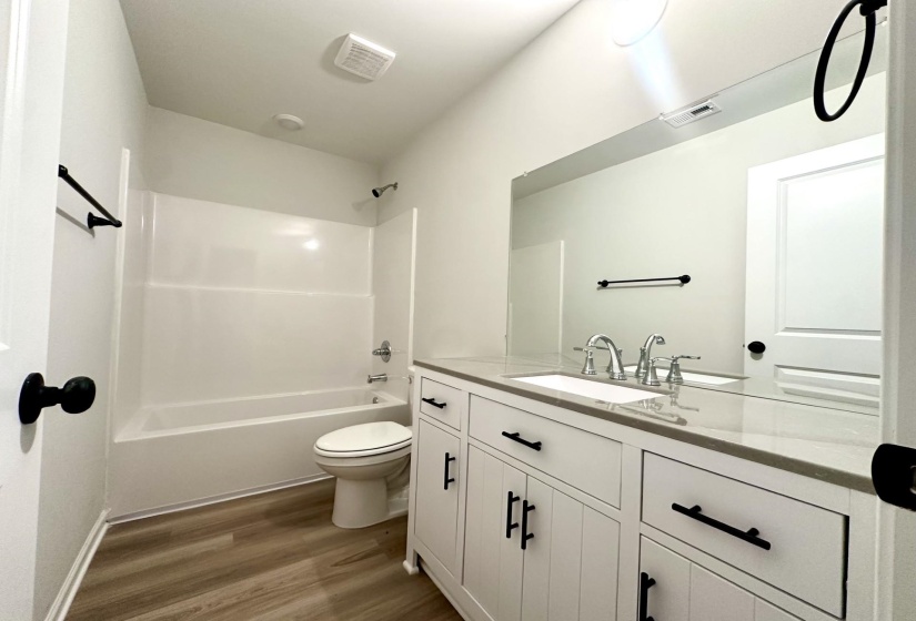 Bathroom featuring a white vanity with a stone countertop, an integrated sink, and brushed nickel fixtures