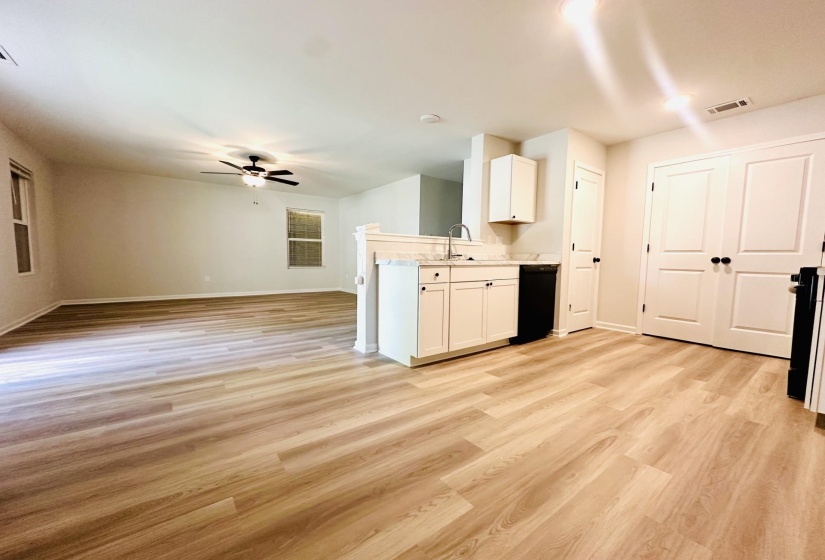 Open-concept living area with wood-finish flooring, recessed lighting, and a ceiling fan