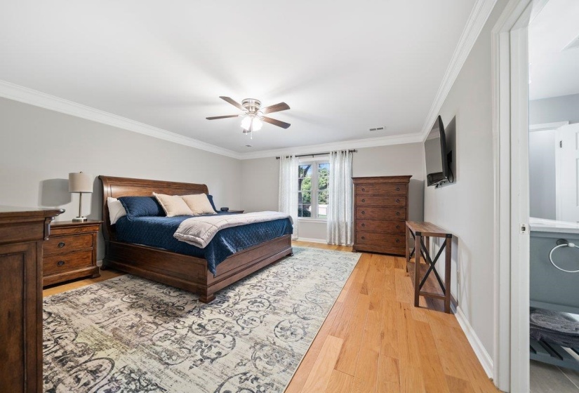 Spacious room featuring light wood-finish flooring, crown molding, a ceiling fan