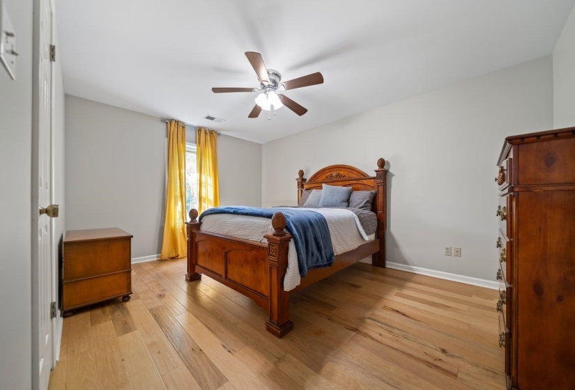 Spacious room featuring wood-finish flooring, a ceiling fan