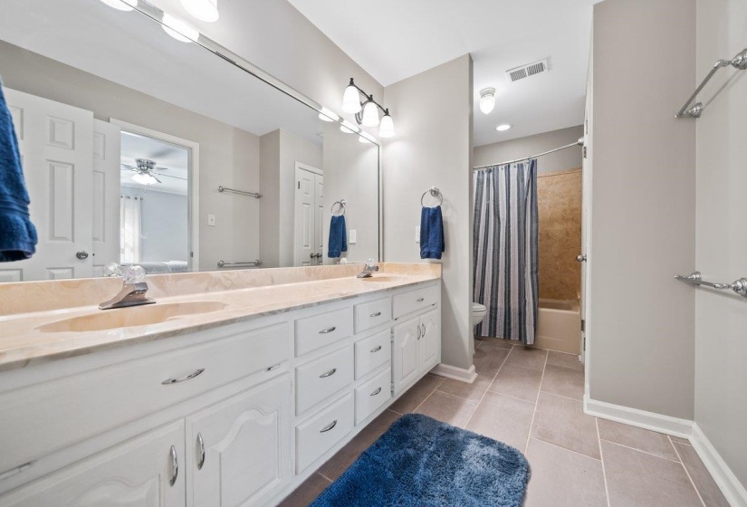 Dual vanity featuring white cabinetr and a neutral-toned countertop