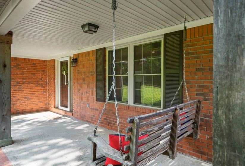 Covered porch featuring brick siding