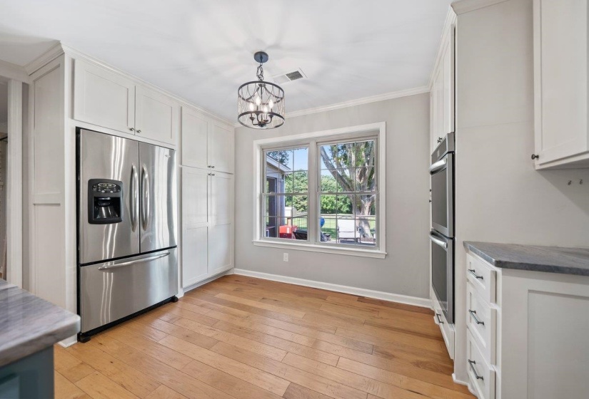 Renovated Kitchen featuring, white cabinetry, and stainless steel appliances, with new double ovens