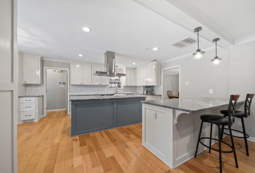 Modern kitchen featuring a two-tone island design with a gray base and white cabinetry