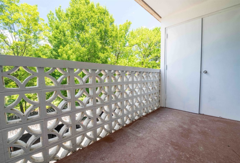 Private balcony with decorative block railing, offering an open-air extension