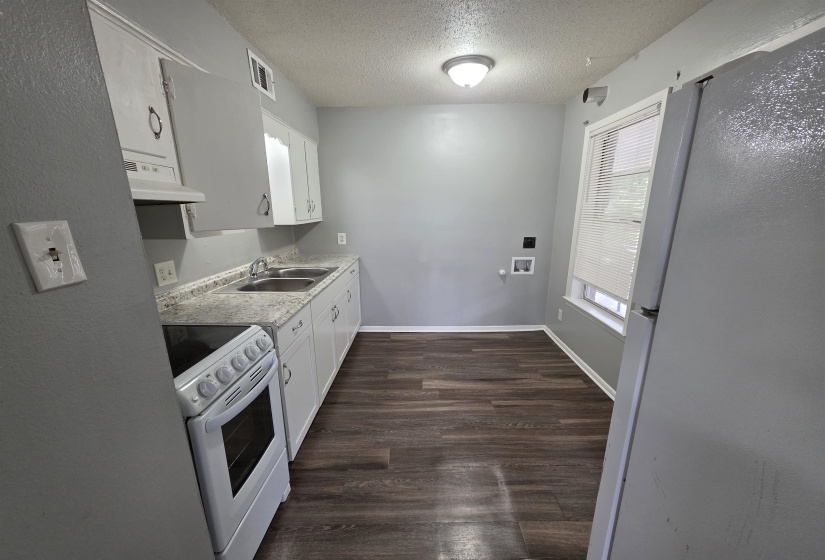 Compact kitchen featuring wood-finish flooring and light gray walls