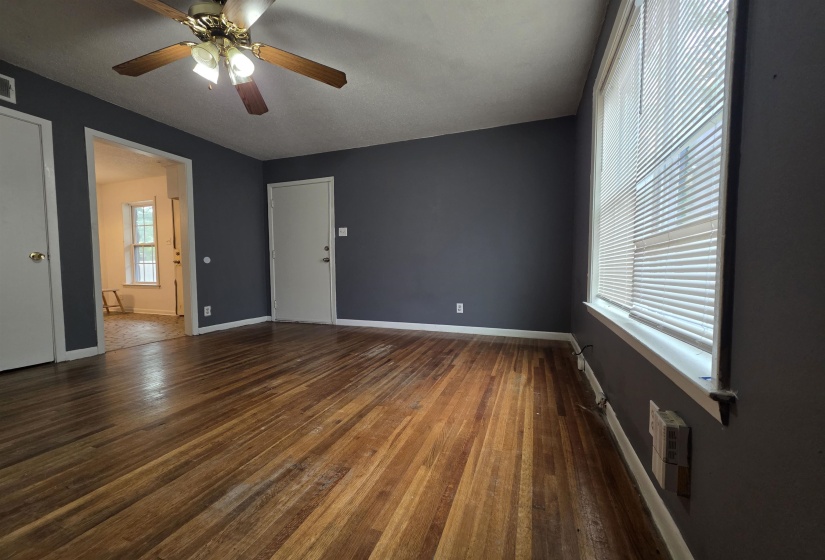 Interior room with wood-finish flooring, dark gray painted walls, and white trim