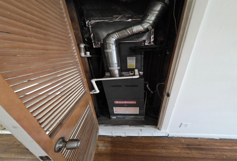 Utility closet featuring a Goodman furnace with visible ductwork