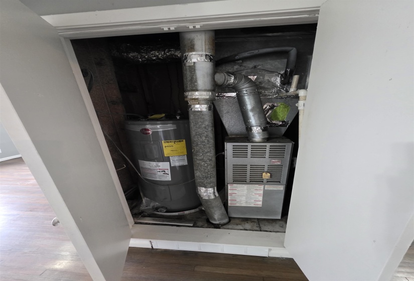 Utility closet housing a water heater and furnace unit