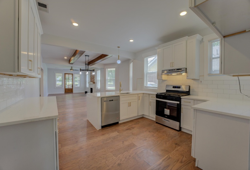 Modern kitchen featuring white cabinetry, light countertops, subway tile backsplash, and stainless steel appliances