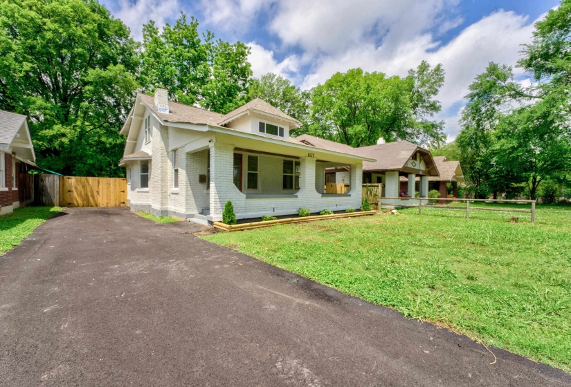 White brick exterior featuring a covered front porch and a gabled roofline