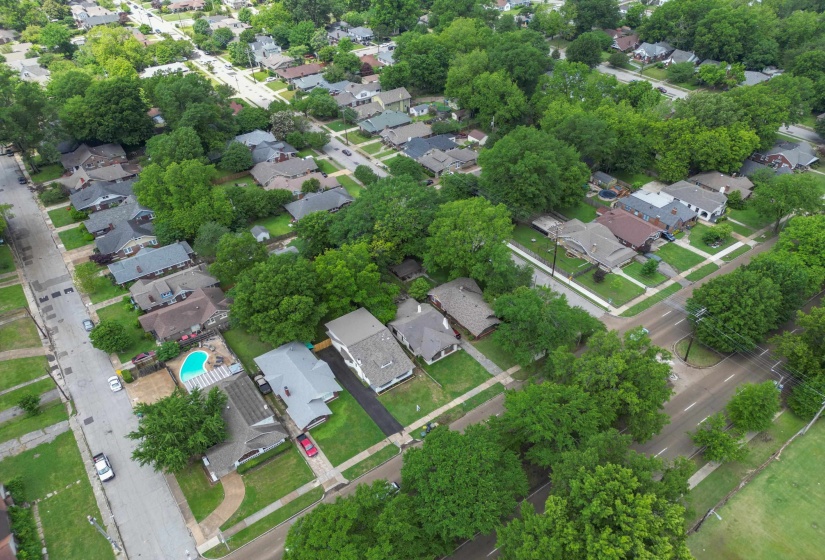 Aerial perspective showcasing a residential neighborhood with mature tree coverage