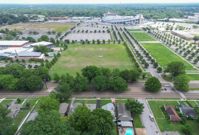 Aerial perspective showcasing residential properties with private swimming pools, surrounded by mature trees