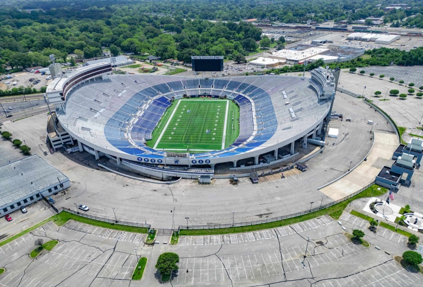 Stadium complex featuring extensive paved areas and surrounding structures