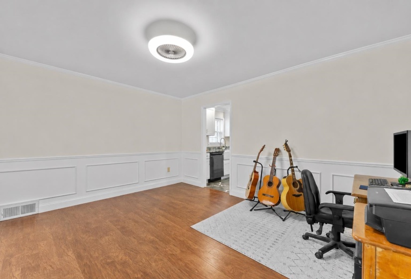Spacious formal dining room featuring decorative wainscoting, crown molding, and flexible space for hosting holiday meals, dinner parties, and special gatherings.