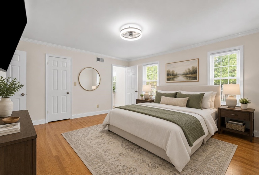 Generously sized primary bedroom featuring hardwood floors, abundant natural light, and plenty of space for a king-size furniture arrangement.