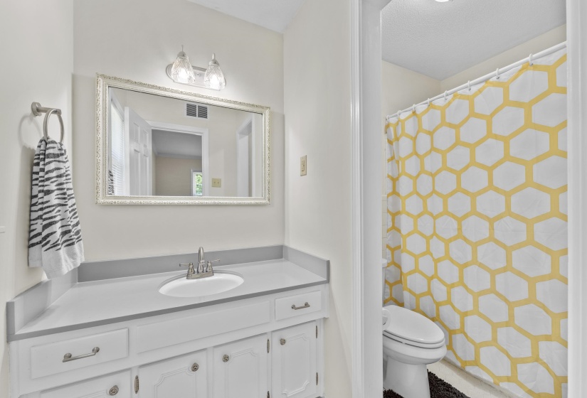 Private primary bathroom featuring a nice vanity, abundant storage, and a bright, comfortable design.