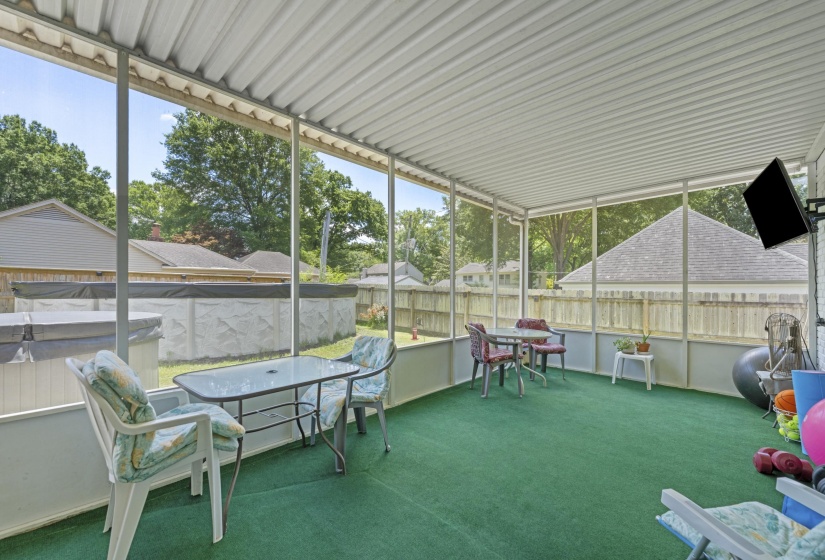 Enjoy outdoor living year-round in this large screened sunroom featuring plenty of space for lounging, dining, and entertaining while staying protected from the elements.