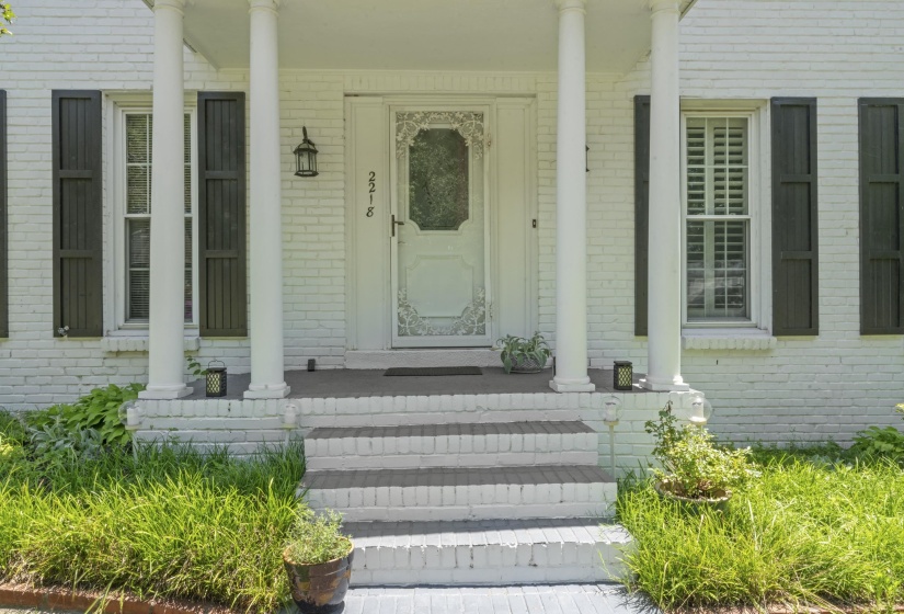 Classic Southern charm welcomes you home with stately columns, painted brick, and a covered front porch entry.