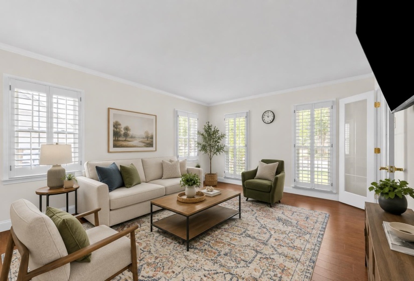 Spacious living room filled with natural light from plantation-shuttered windows and French doors. Virtually staged to showcase the room's comfortable layout and entertaining potential.