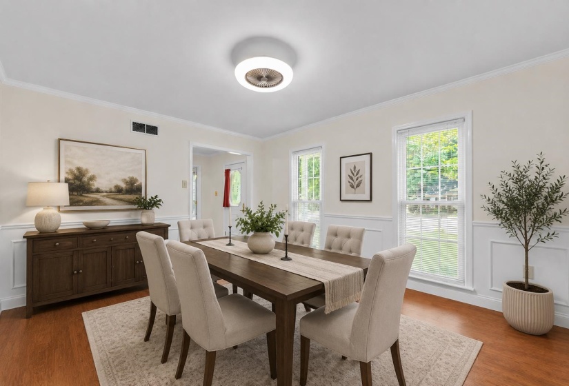 Beautiful formal dining room featuring classic wainscoting, abundant natural light, and ample space for hosting family dinners and holiday gatherings. Virtually staged to showcase the room's versatility, warmth, and timeless charm.
