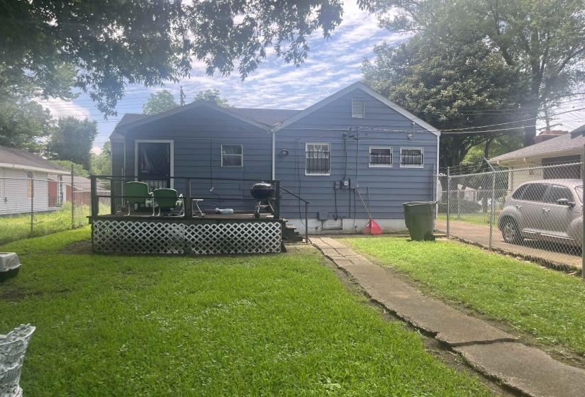 Rear exterior featuring blue siding and a raised deck with lattice skirting