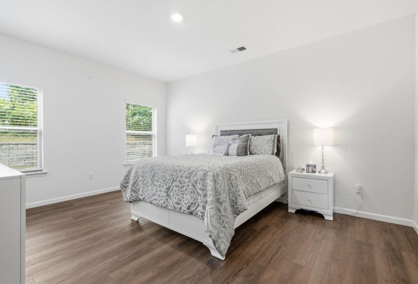 Primary Bedroom featuring wood-finish flooring, white walls, and two windows with blinds