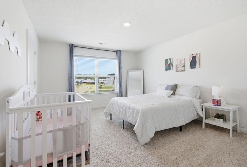 Large carpeted room with a large window featuring horizontal blinds and blue drapes