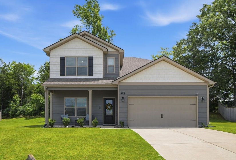 Contemporary two-story exterior featuring a covered front porch, a two-car garage, and a concrete driveway