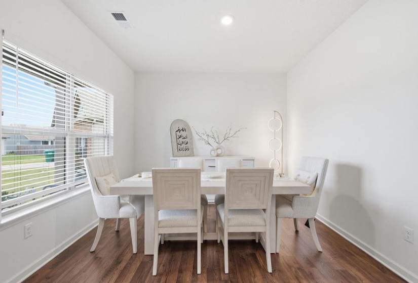 Dining Room featuring wood-finish flooring, white walls, and a large window with horizontal blinds