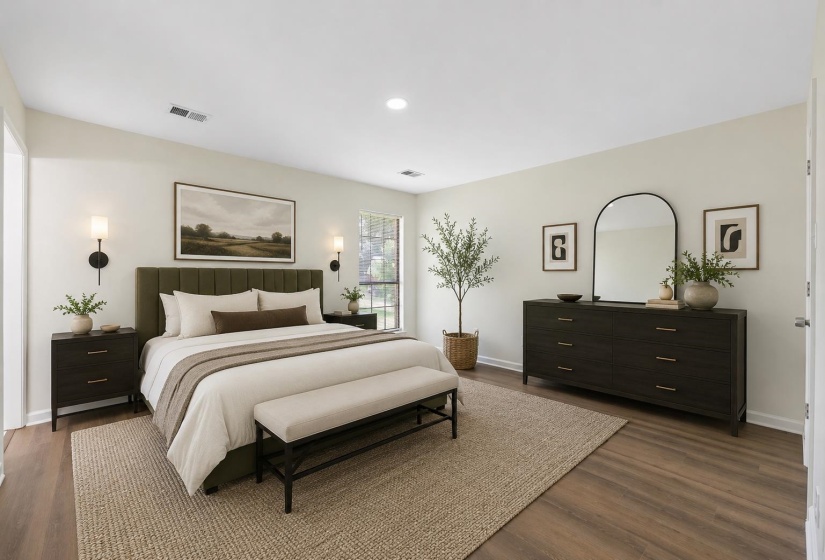 Generously sized primary bedroom featuring updated flooring, neutral colors, abundant natural light, and plenty of space for large furnishings and a relaxing retreat. This photo has been virtually staged.