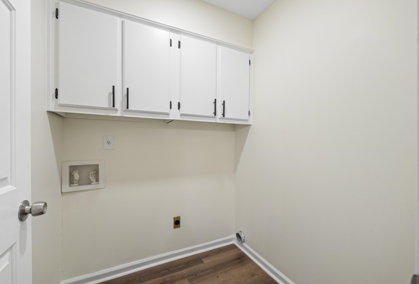 Separate laundry room with built-in cabinetry providing valuable storage and organization space for everyday convenience.