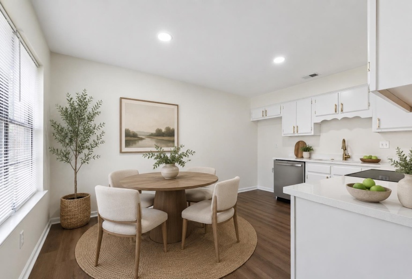 Enjoy casual dining in the bright eat-in kitchen featuring freshly painted white cabinetry, granite countertops, stainless steel appliances, and updated fixtures. This photo has been virtually staged.